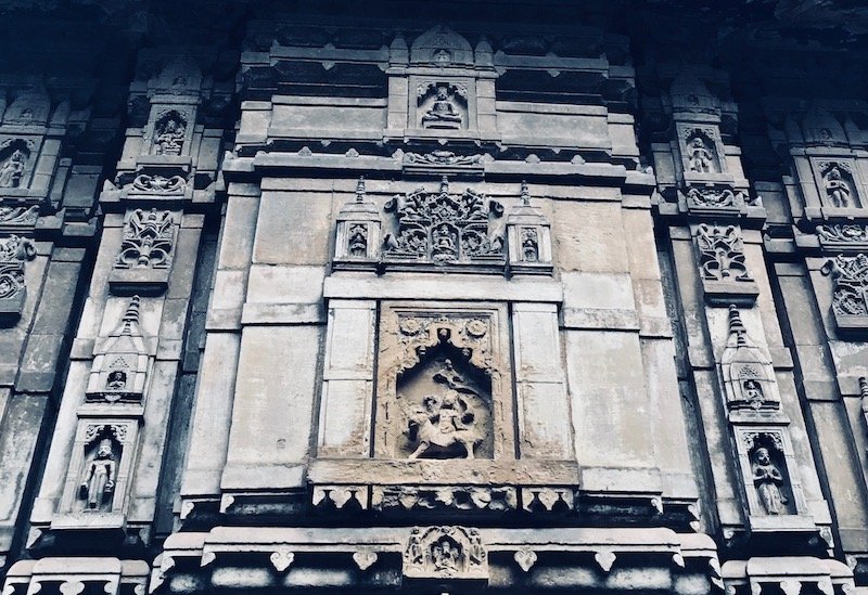 Shiva temple facade with carved stone in Varanasi, India | solo travel to Benaras | Header image for travel story My Varanasi Day Tour with a Shiva Devotee - Shiva City on travel blog Teja on the Horizon