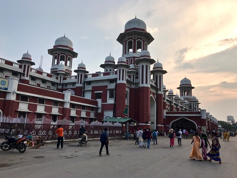 Travel article 'The Tuktuk Driver at the Lucknow Train Station' | Sun setting behind the many-domed red and white building of Lucknow train station | Teja on the Horizon blog