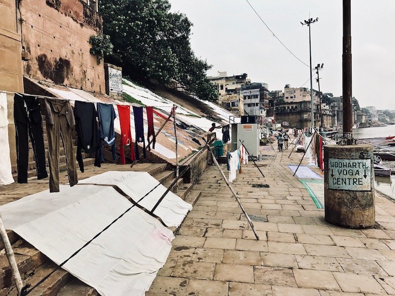Travel article "Why You Shouldn't Fear Scams in India" on the sustainable travel blog Teja on the Horizon | View up Babua Pandey Ghat by the river Ganges in Varanasi, India | Laundry hung out to dry on a ghat in Banaras | How to deal with scams in India | personal growth and character development opportunity