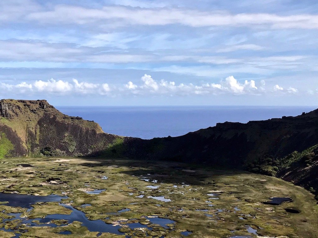 'Launching My Pacific Odyssey on the Trail to Orongo' travel story on slow travel blog Teja on the Horizon | The rim of Rano Kau volcano crater lake looking out to the Pacific Ocean