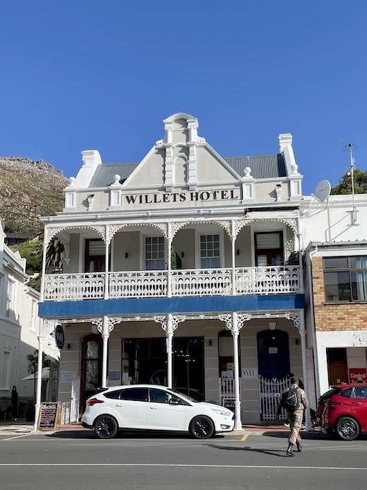 19th century colonial facade architecture of the Willets Hotel along St Georges Street in Simon's Town, with filigreed arches and filigree railings on the upper balcony gallery.